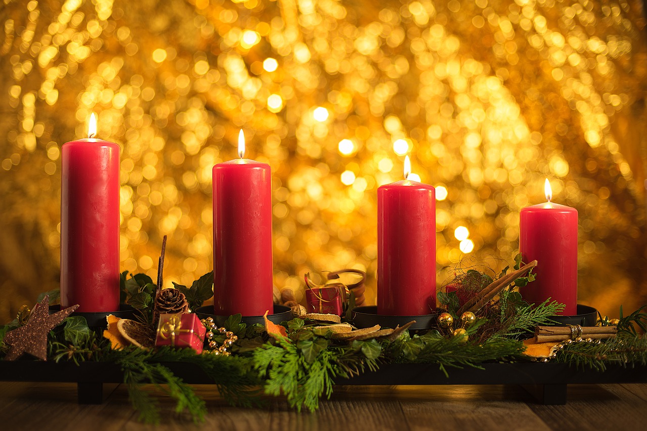 Four red candles lit for advent at Christmas time.