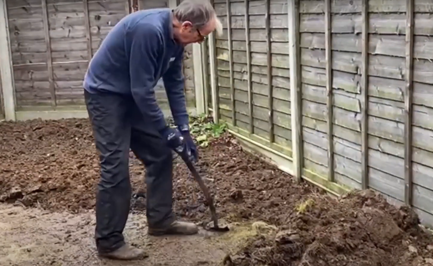 Ken Crowther digging a garden.